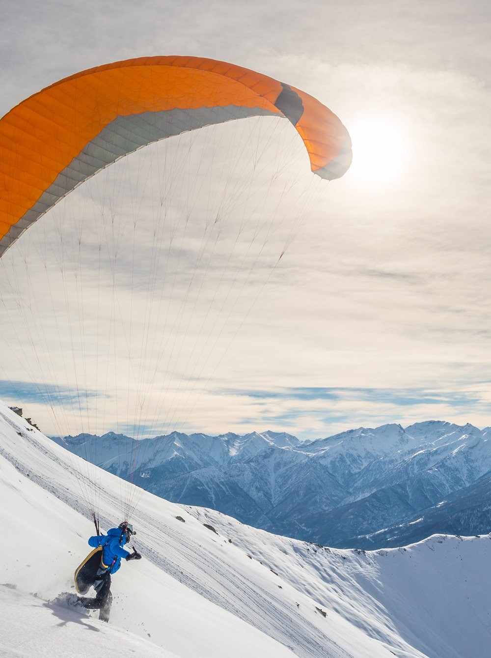 Paragliding über den verschneiten Bergen von Salzburg width=